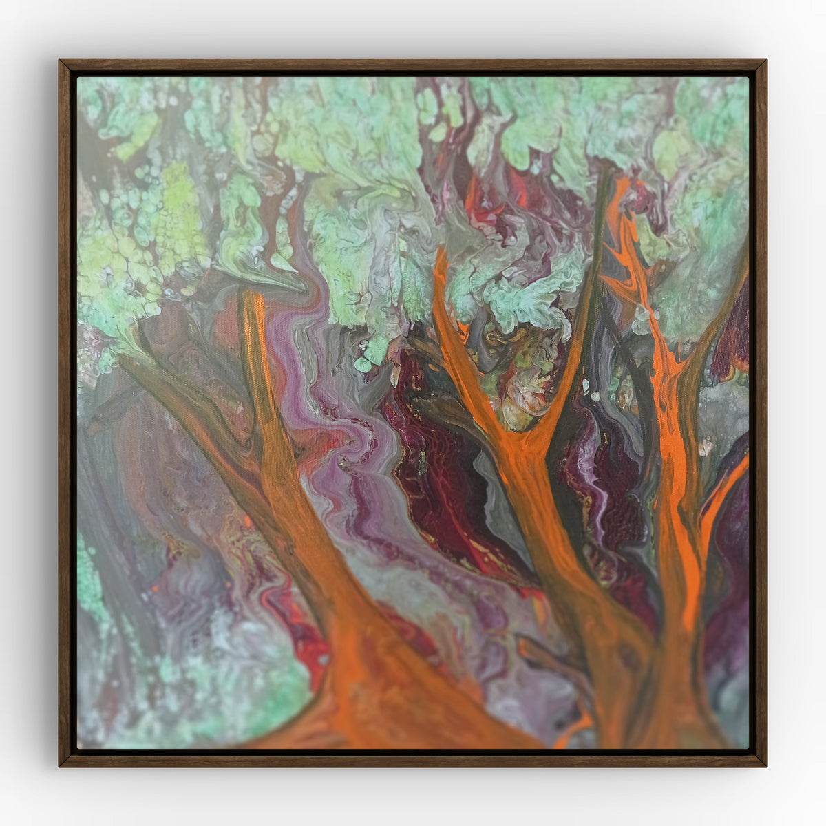 Abstract painted black frame wall art featuring swirling marbled paint in orange, purple, green, gray, and red, enclosed in a dark brown square frame against a light gray wall.